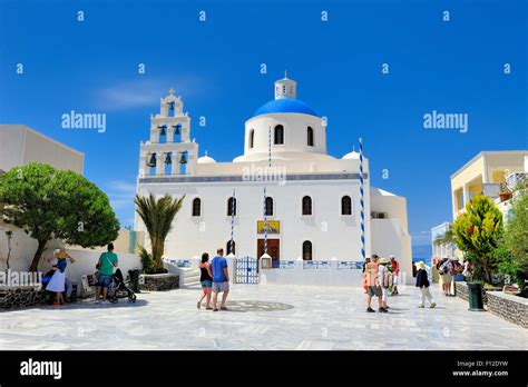 Tourists Walking In The Square At The Church Of Panagia Of Platsani Oia