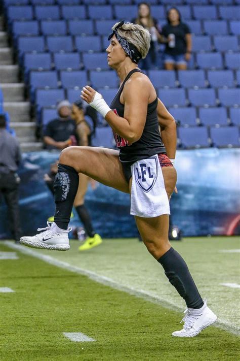 A Woman Running Across A Field In Front Of A Crowd