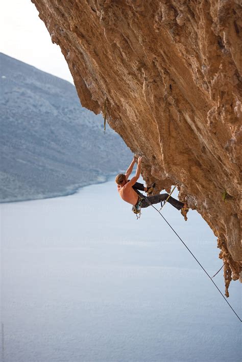 "Man Climbing A Steep Rock Wall Over The Sea" by Stocksy Contributor ...