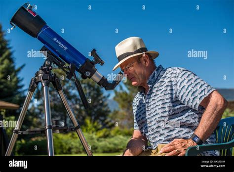 Man looking at solar eclipse with telescope Stock Photo - Alamy