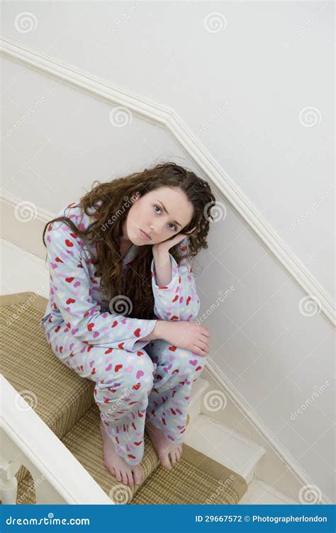 Jeune Femme Triste S Asseyant Sur L Escalier Dans Des Ses Pyjamas Photo