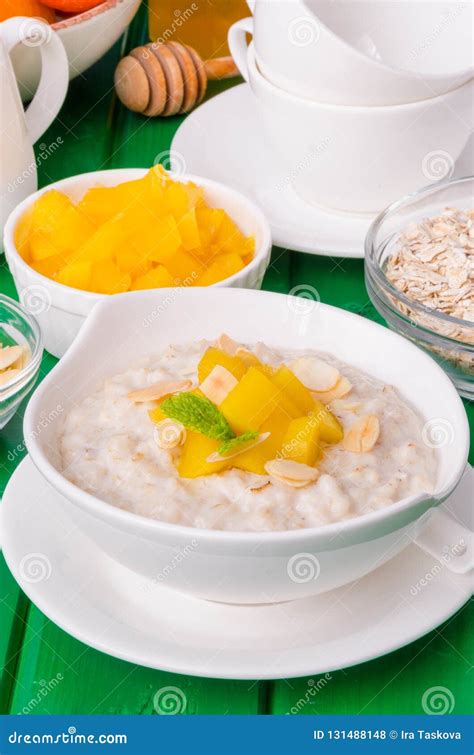 Gachas De Avena De La Harina De Avena Con El Mango Y Las Almendras Para