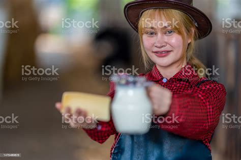 Young Female Dairy Farmer Hand Holding Jug Of Fresh Milk And Cheese