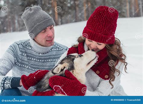 Young Couple With A Husky Dog Walking In Winter Park Man And Woman