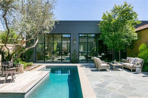 Dark Gray Painted Brick Home With Black Steel Doors And An Outdoor