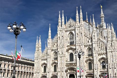 Fachada De Milan Cathedral Con Las Banderas En El Cielo Azul Banderas