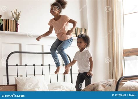 Happy Little African Kids Boy and Girl Jumping on Bed Stock Photo ...