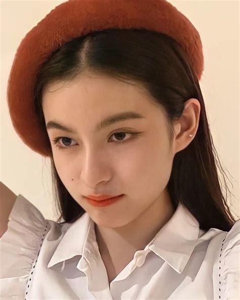 A Woman Wearing A Red Hat And White Shirt