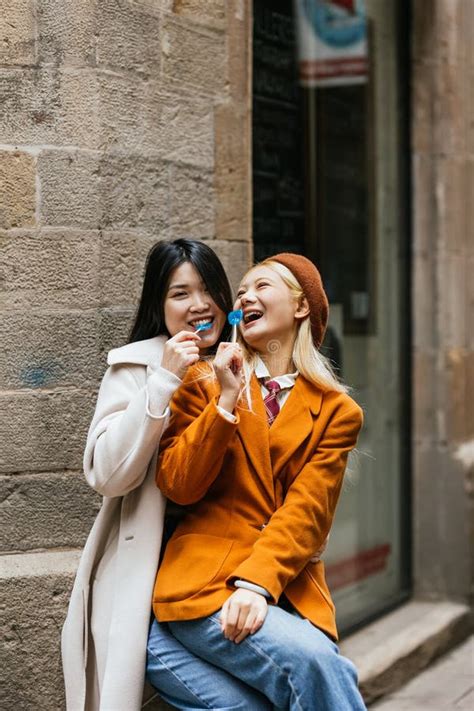 Asian Lesbian Couple Having Fun While Eating Lollipops Together Outdoors Stock Image Image Of
