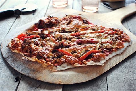 Thin Crust Pizza With Caramelized Onions Sausage And Roasted Red