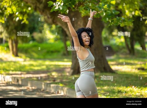 Pretty Curly Haired Brunette Woman In A Park Looking Happy Stock Photo Alamy
