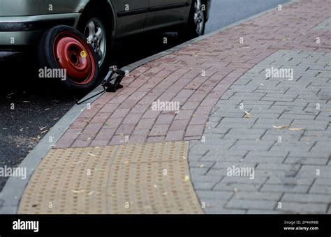 Jacking up a car to change a tyre after a roadside puncture with the ...