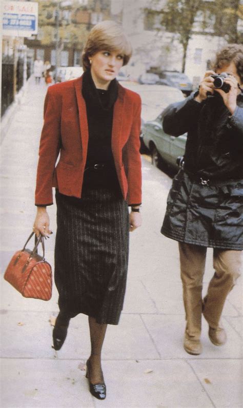 Two Women Are Walking Down The Sidewalk While One Is Taking A Photo