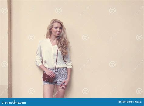 Beautiful Blonde Woman With Long Hair Posing At The Wall With Vintage