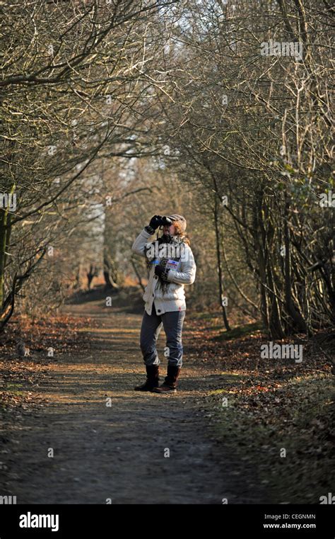 Female Birdwatcher With Binoculars And Identification Book At The Rspb