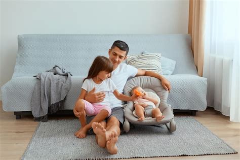 Foto Horizontal De Um Jovem Pai Otimista E Positivo Suas Filhas