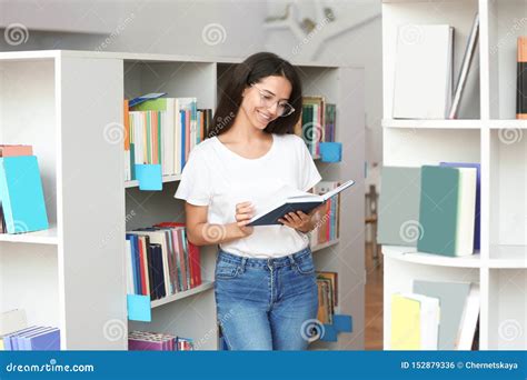 Libro De Lectura De La Mujer Joven En Biblioteca Foto De Archivo