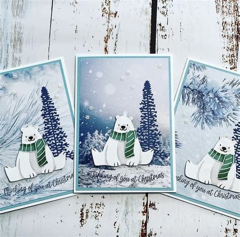 Three Polar Bear Christmas Cards Sitting On Top Of A Wooden Table