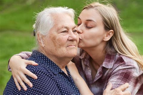 Premium Photo Loving Granddaughter Kisses Her Grandmother On The Cheek