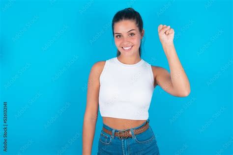 Beautiful Brunette Woman Wearing White Tank Top Over Blue Background