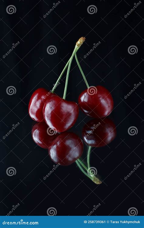 Three Red Cherries On A Black Background With Reflection Fresh