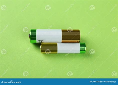 Different Batteries On Light Green Background Flat Lay Stock Photo