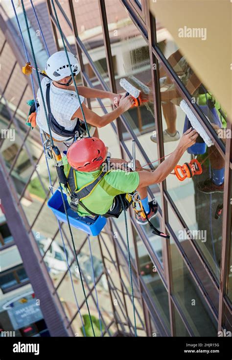 Industrial Mountaineering Workers Washing Glass Windows Of High Rise