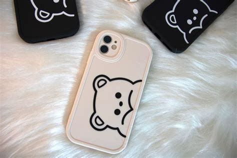 Three Cell Phones With Black And White Designs On Them One Has A Bear Face