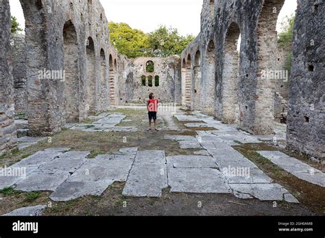 Boy standing in the middle of ruins of ancient city Butrint in Butrint ...