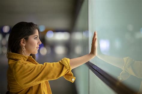 Vista Lateral De Una Mujer Joven Tocando La Ventana Foto Premium