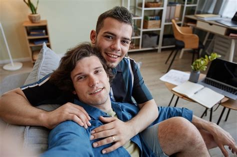 Retrato de una joven pareja gay tomando una foto selfie abrazándose en una nueva cámara casera