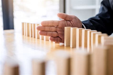 Premium Photo Businessman Hand Stopping Falling Wooden Dominoes Effect