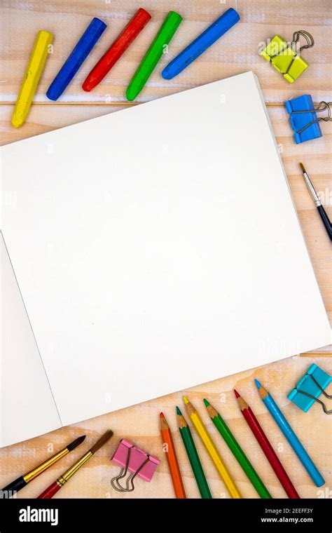 Blank page of open sketchbook with art tools on wooden table. Artistic table top view photo ...