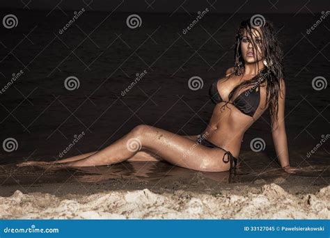 Dame Attirante De Brune Posant Sur La Plage La Nuit Image Stock