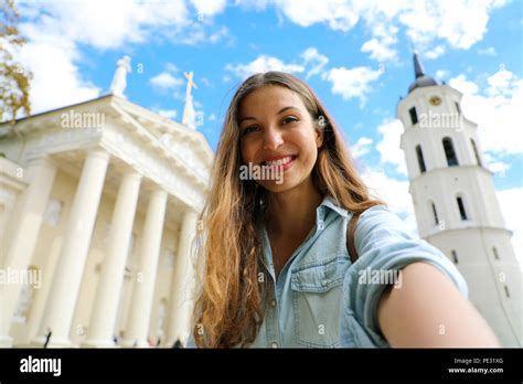 Happy smiling girl taking selfie picture in front of Vilnius Cathedral ...