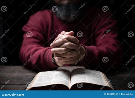 Hands Folded In Prayer On A Holy Bible In Church Concept For Faith