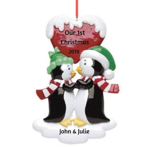 Two Penguins Are Holding Each Other On A Christmas Ornament With The