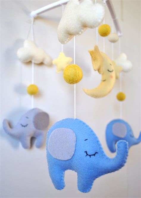 An Elephant Mobile Is Hanging From The Ceiling With Clouds And Stars On