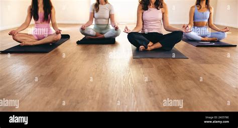 Unrecognizable Women Doing Sukhasana Meditation During A Yoga Class