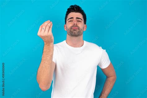 Young Man Wearing White T Shirt Over Blue Studio Background Angry