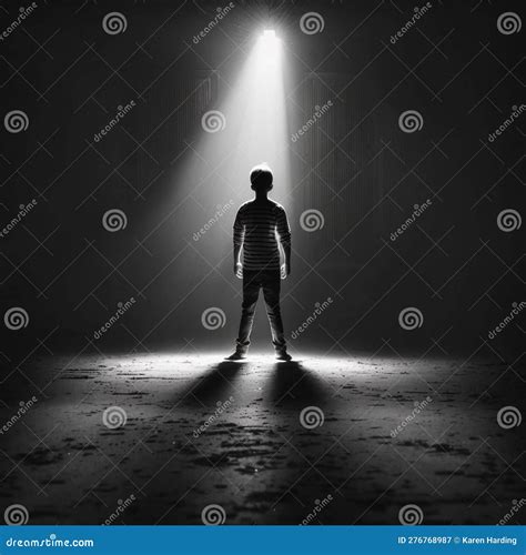 Silhouette Of Person In Darkness Lit Up By A Single Light Stock