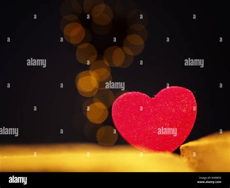 Close Up Of A Red Wooden Heart Shape With Blurred Heart Shaped Lights