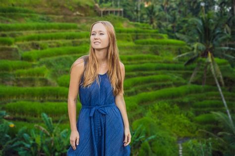 Mujer joven en la plantación de campo de arroz en cascada verde en la