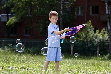 Fondo Niño Pequeño Se Juega Con Pompas De Jabón En La Calle Foto E