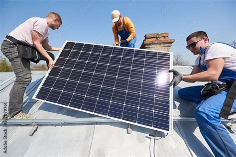 Male Team Workers Installing Solar Photovoltaic Panel System Three