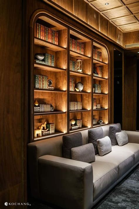 A Couch Sitting In Front Of A Book Shelf Filled With Books