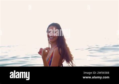 Beautiful Girl In A Bikini Has Fun In The Water At Sunset And Asks To