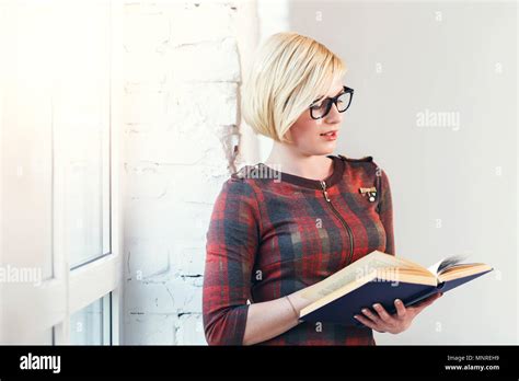 Pretty Intelligent Blonde Woman Wears Eyeglasses And Red Dress Reading