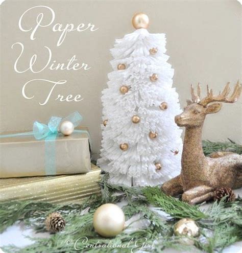 A White Christmas Tree Sitting Next To A Stack Of Books On Top Of A Table