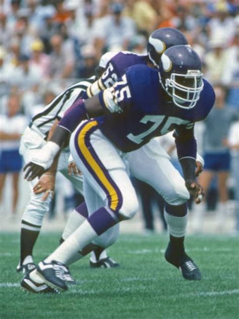 A Football Player Holding The Ball During A Game